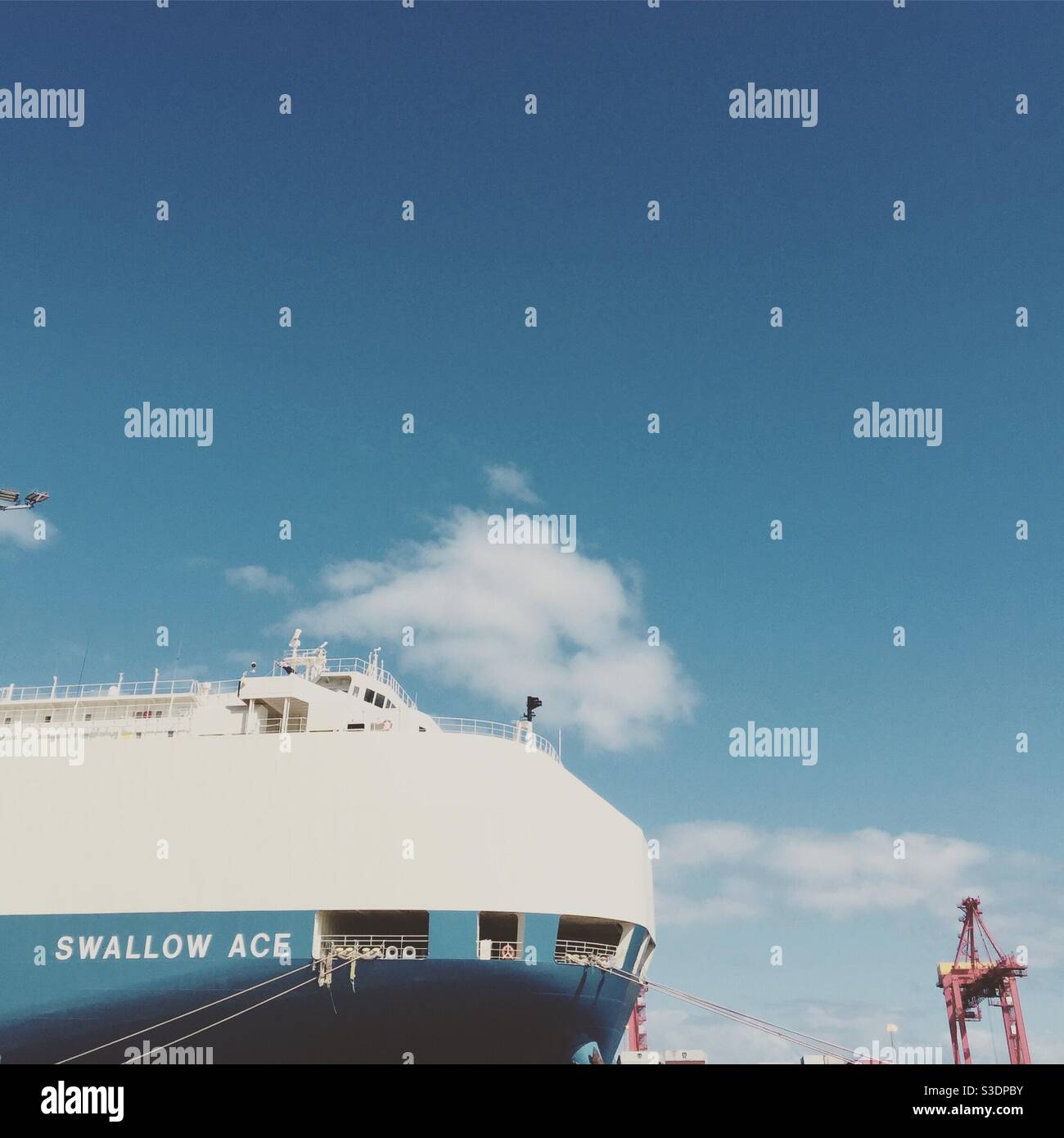 Ship in port with cranes and blue skies Stock Photo