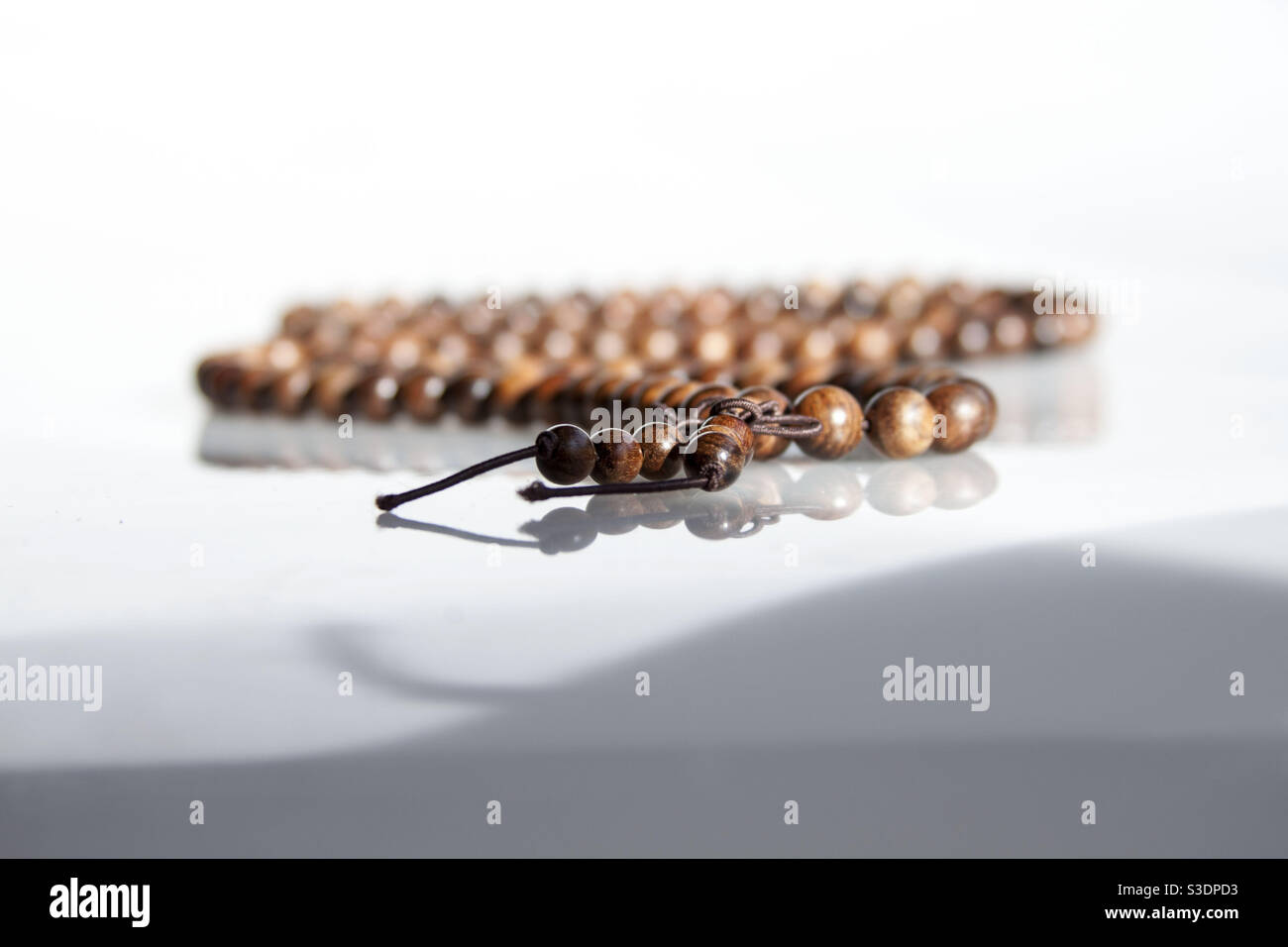 Vintage brown wooden prayer beads up close isolated on white background Stock Photo