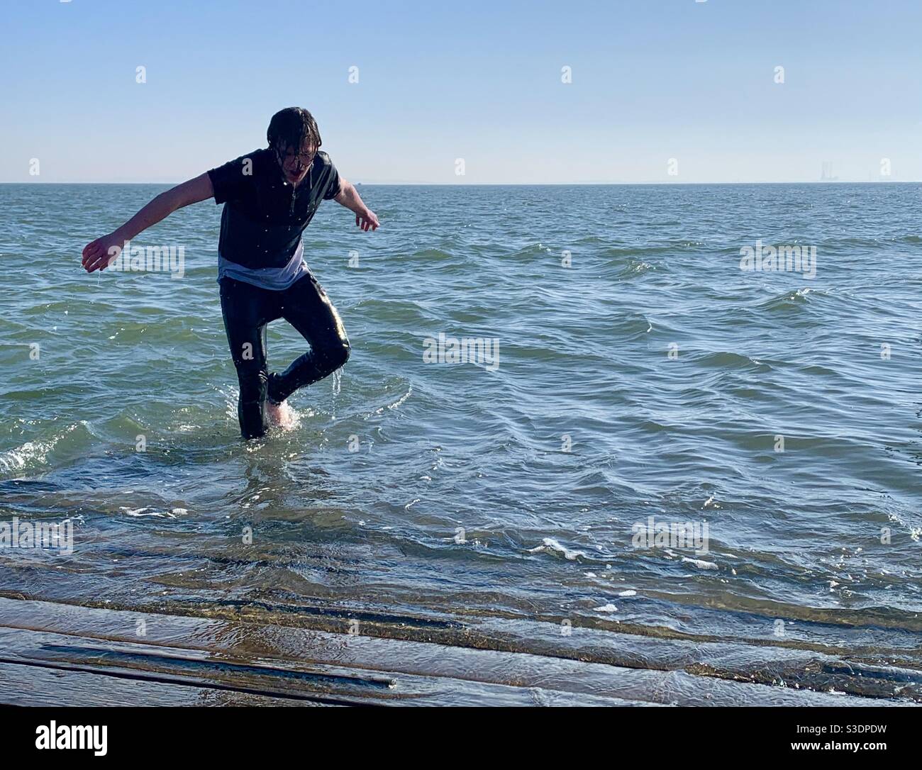 Young boy emerging from water after jumping in with clothes on Stock Photo  - Alamy