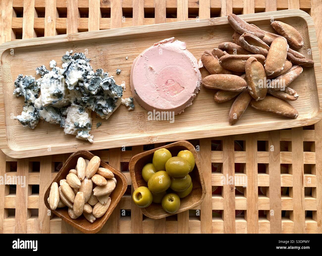 Appetiser with blue cheese, foie, picos, almonds and olives on a wooden background Stock Photo