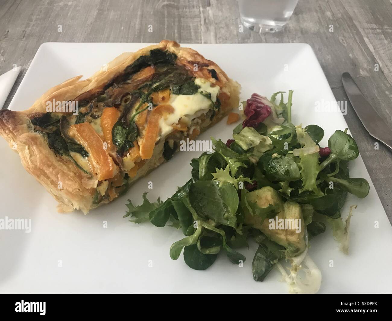 Homemade salmon and vegetable quiche served with a mixed salad - Smartphone Captured Stock Image