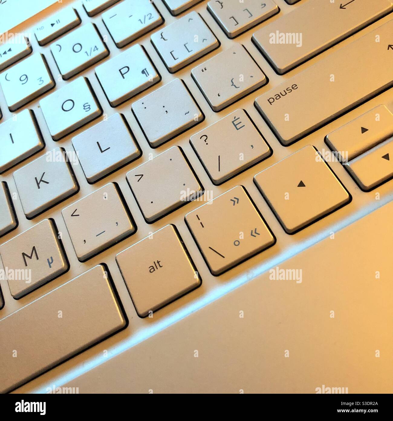View of the keyboard of a laptop highlited by blue amd yellow lights - Smartphone Captured Stock Image