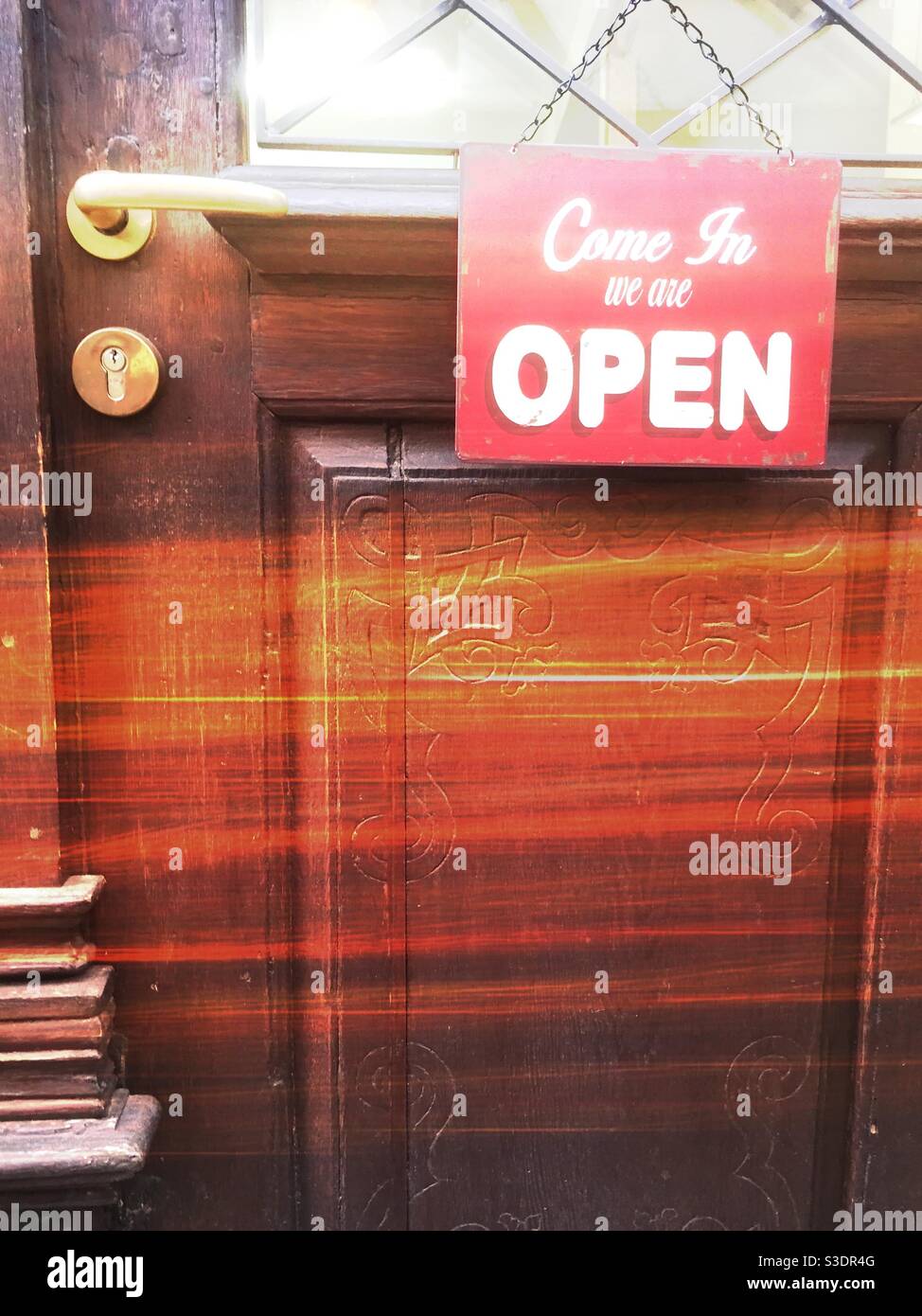 Come in we’re open sign on old wooden door - Smartphone Captured Stock Image