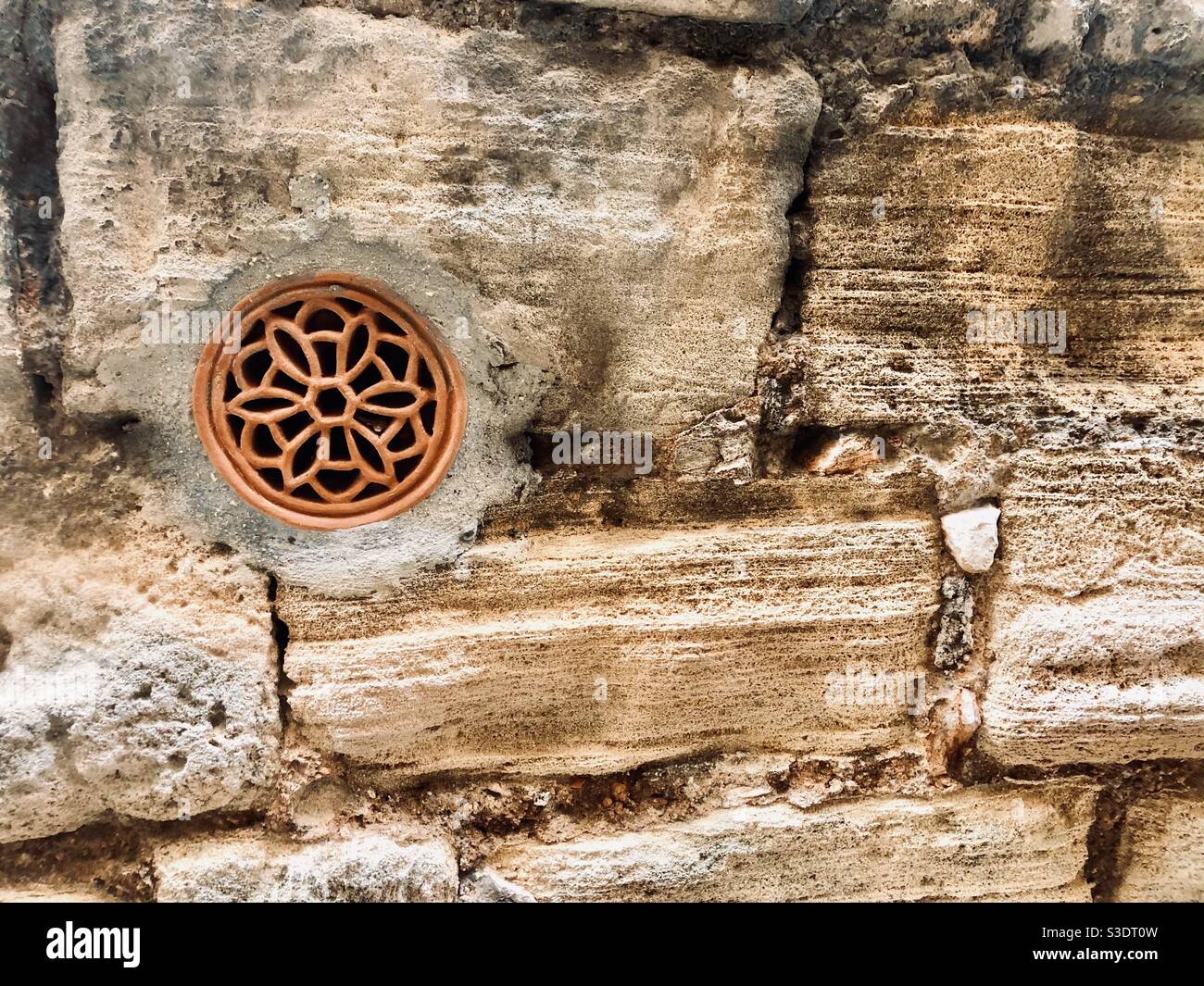 Red rosette in old city wall - Smartphone Captured Stock Image