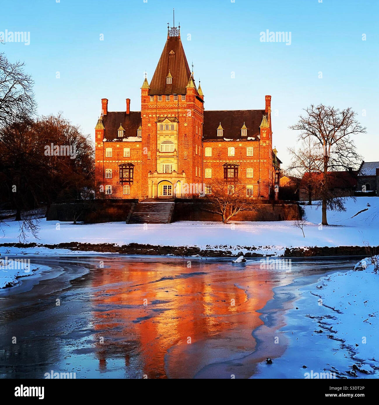 Trollenäs castle in Skåne and it’s reflection on ice on a frozen sunny winter day Stock Photo