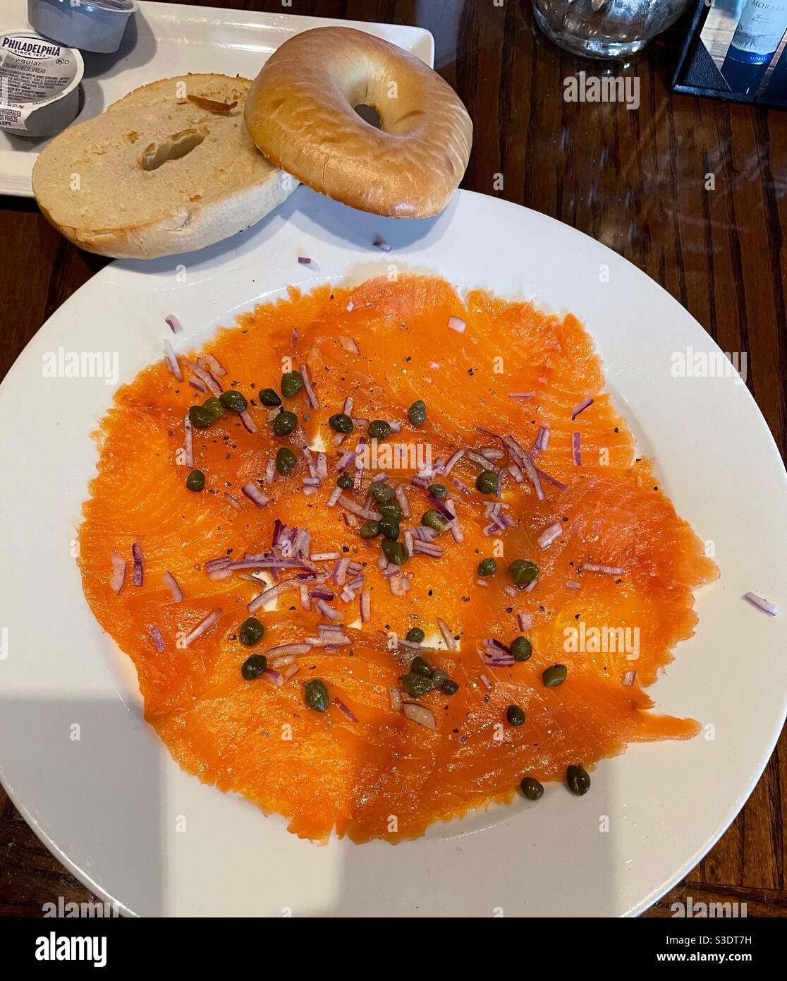 A delicious plate of lox, capers, red onions, on a white plate with a side of toasted sliced bagels and Philadelphia cream cheese at Primos kitchen bar in the Hilton grand hotel Biscayne Bay, Miami - Smartphone Captured Stock Image A delicious plate of lox, capers, red onions, on a white plate with a side of toasted sliced bagels and Philadelphia cream cheese at Primos kitchen bar in the Hilton grand hotel Biscayne Bay, Miami - Smartphone Captured Stock Image