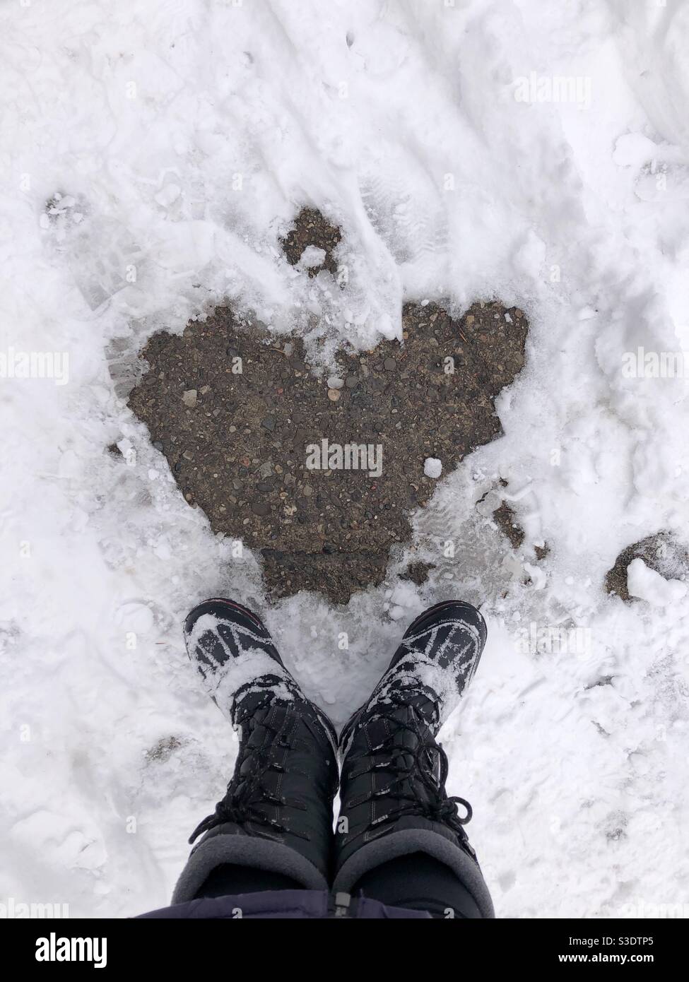 Heart-shaped outline on the snowy ground. - Smartphone Captured Stock Image