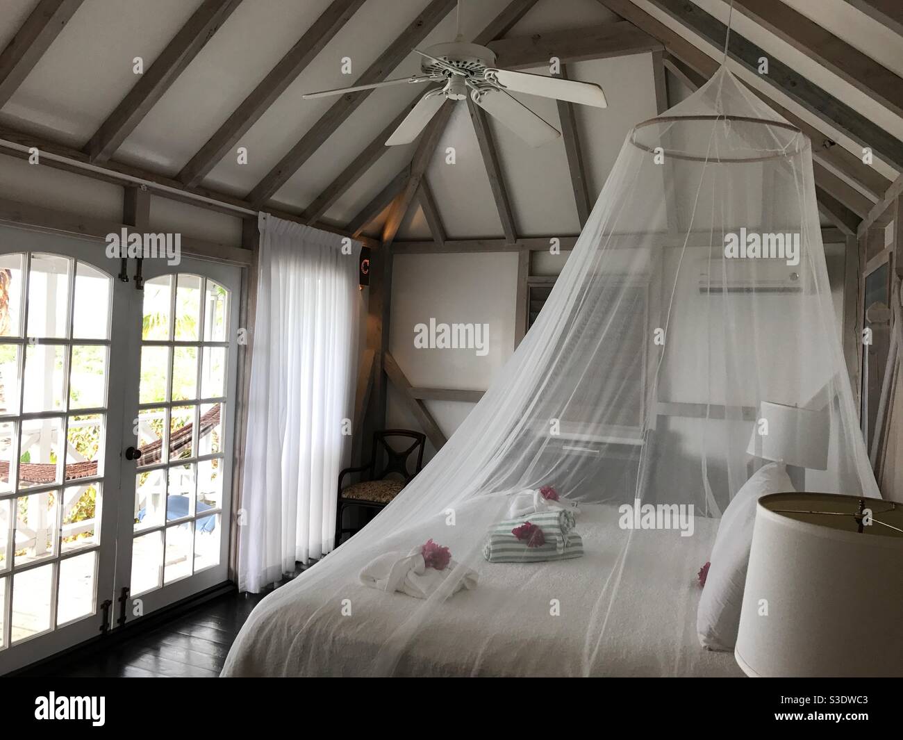 Chambre romantique avec un lit double couvert au-dessus, en haut de la table  de chevet, et d'une fenêtre ensoleillée Photo Stock - Alamy