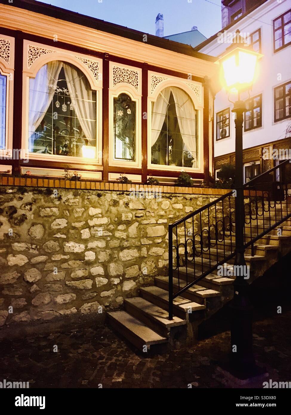 Stairs and restaurant windows in old inner town in the evening in Sopron, Hungary Stock Photo