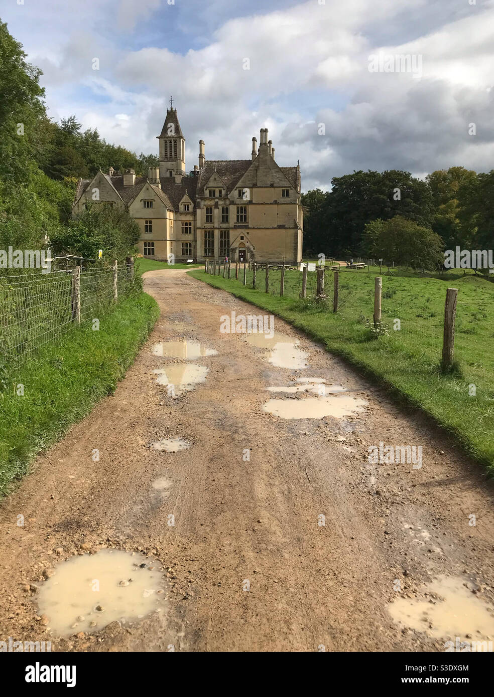 A muddy path with puddles, leading to Woodchester mansion, in Woodchester Park, in the Cotswolds. Near Stroud, Gloucestershire, England. Stock Photo
