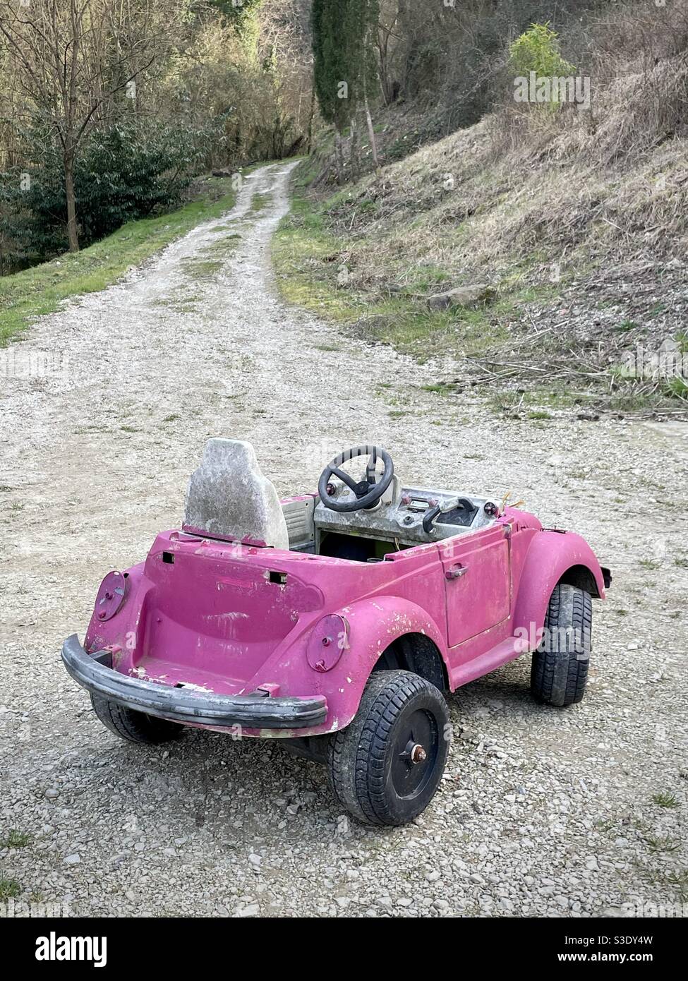 Old used toy car left in a rural road in the countryside in Italy Stock Photo