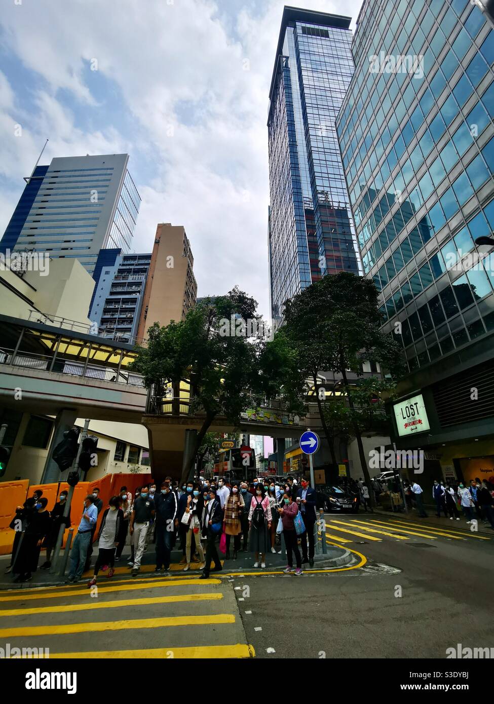 Pedestrians waiting to cross the road on Queens road in Hong Kong. - Smartphone Captured Stock Image