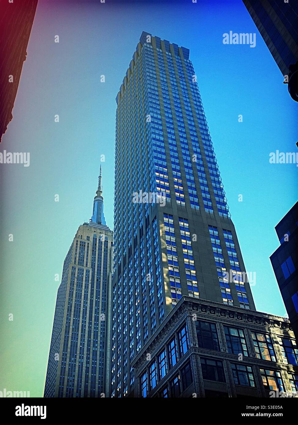 The empire state building and the Langham Hotel are situated along fifth Avenue in Midtown Manhattan, NYC, USA - Smartphone Captured Stock Image