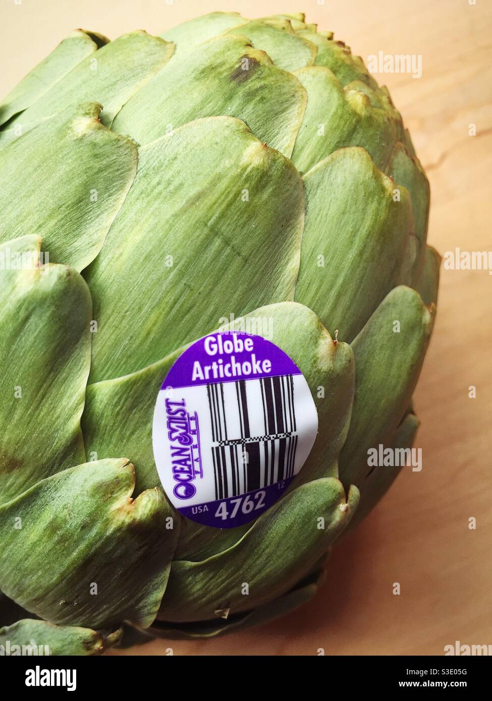 Close up of a fresh globe artichoke with UPC sticker - Smartphone Captured Stock Image