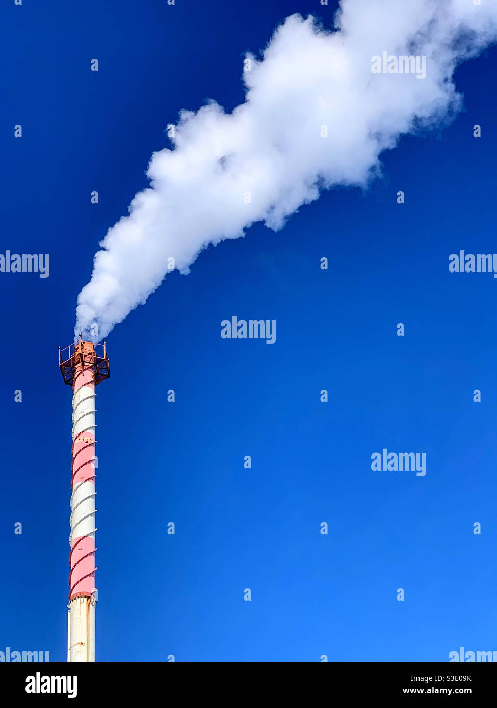 Tall brick chimney with thick white smoke against a blue sky Stock ...