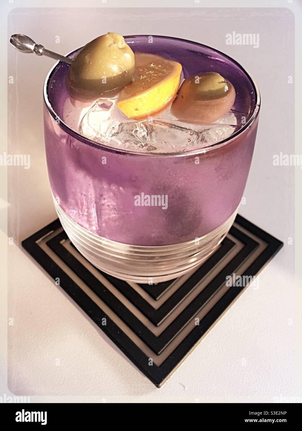 Close up of a vodka martini on the rocks in a crystal amethyst glass on an art deco coaster - Smartphone Captured Stock Image
