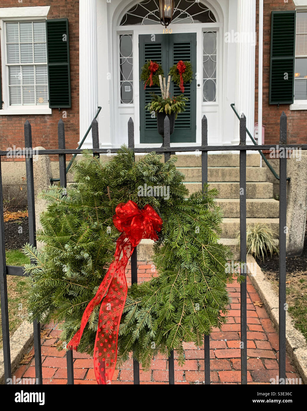 Holiday wreath on a fence in front of a building in Salem, Massachusetts, United States - Smartphone Captured Stock Image