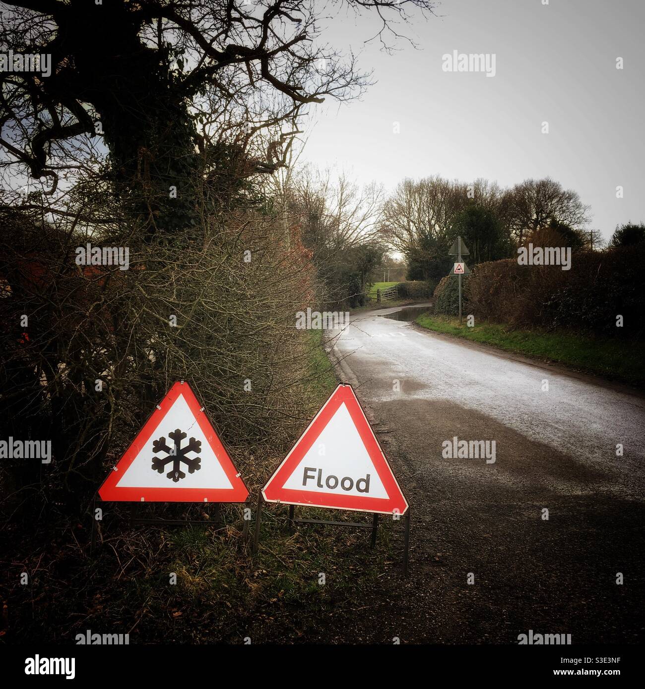 Ice on road with flood traffic warning signs in Cheshire Uk - Smartphone Captured Stock Image