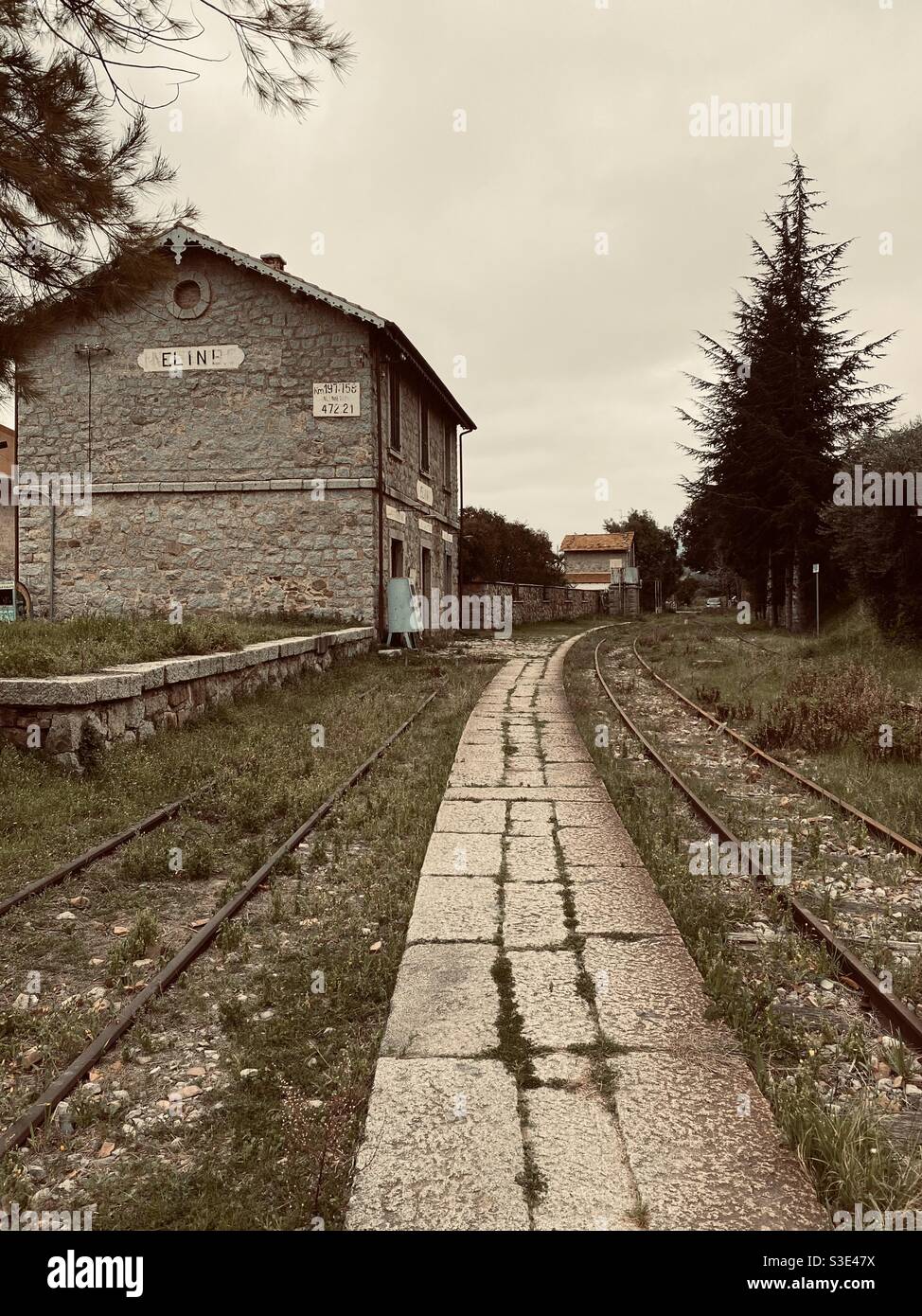 Railroad and building of an old and dismissed train station in a rural town. Stock Photo