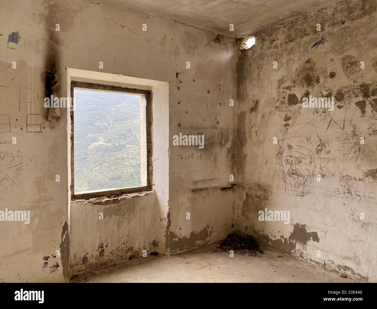 View of a green mountain from a window of a dismissed and abandoned house of Gairo vecchio ghost town, in Sardinia, Italy. Stock Photo