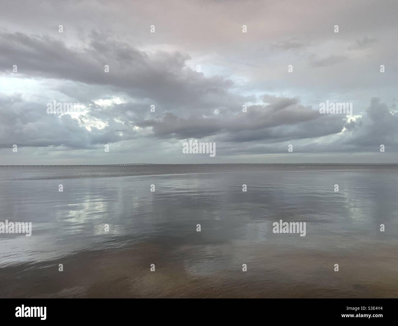 Stormy sunset skies with reflections onto still bay water Stock Photo ...