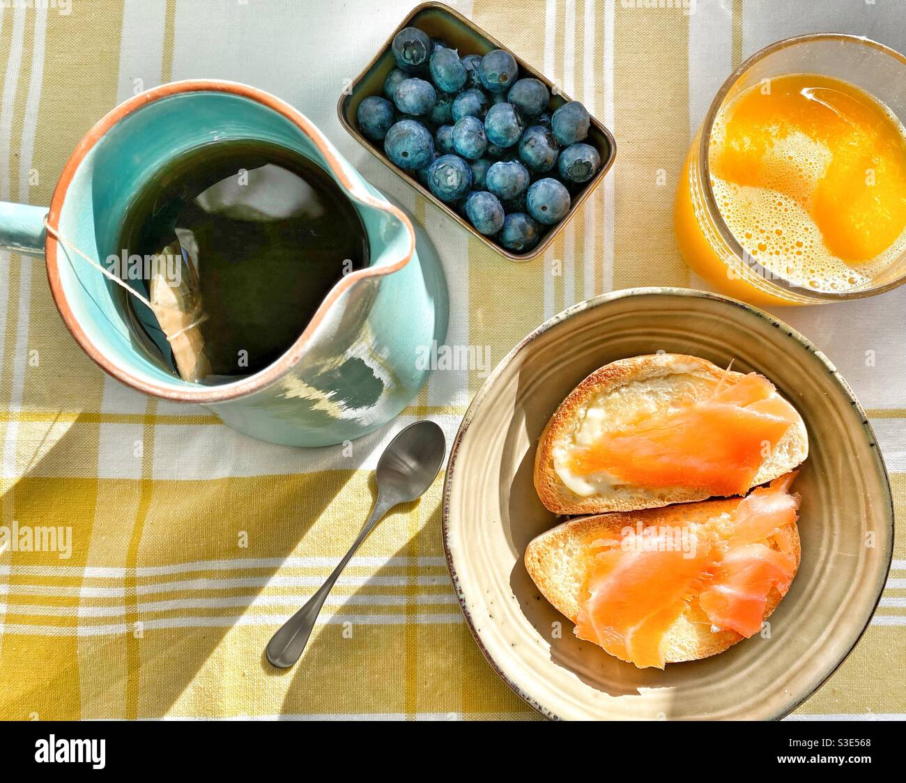 Salmon toast, cranberries, tea and orange juice on a  tablecloth Stock Photo