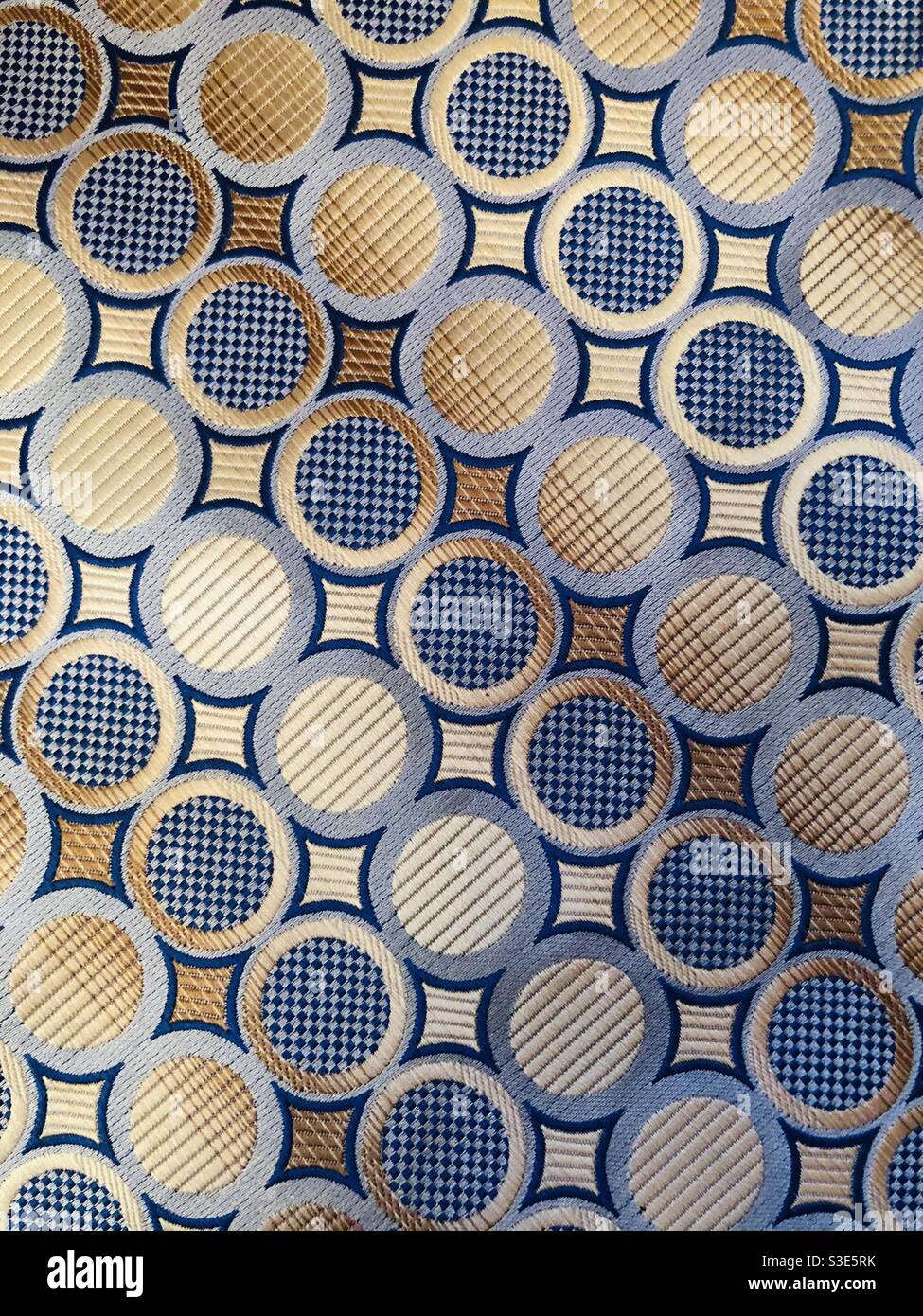 Diagonal shades of blue and gold circles on satin cloth - Smartphone Captured Stock Image