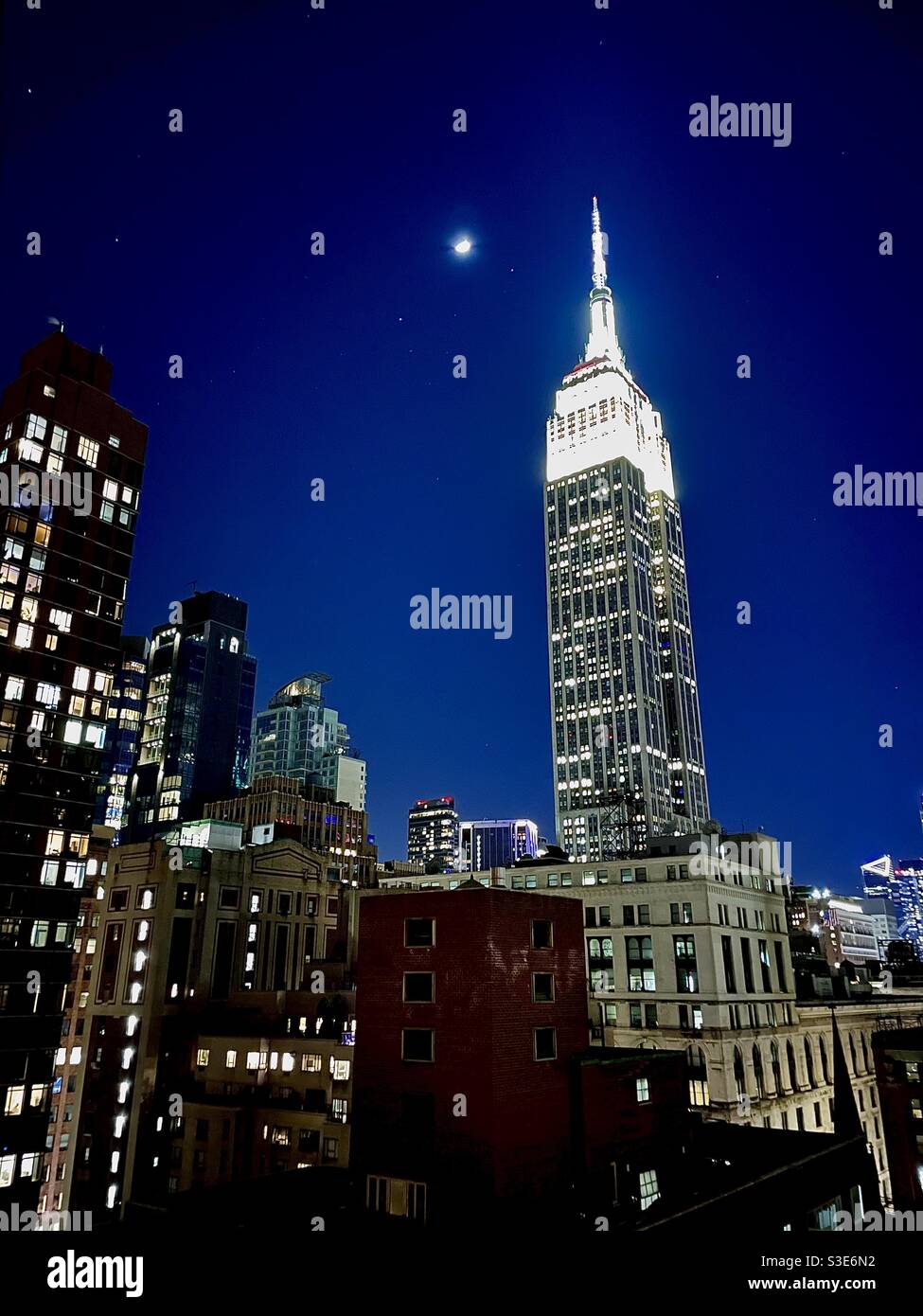 New York City night time silhouette with Empire State building and the moon - Smartphone Captured Stock Image