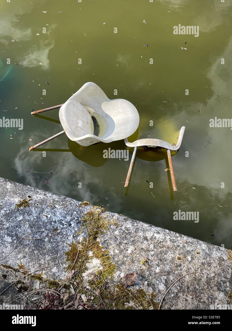 Two chairs abandoned in an old swimming pool Stock Photo