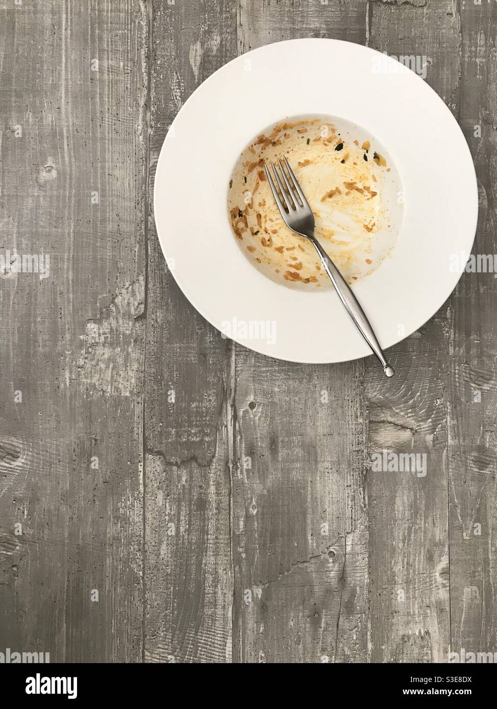 Empty bowl of rice against a wooden background - Smartphone Captured Stock Image