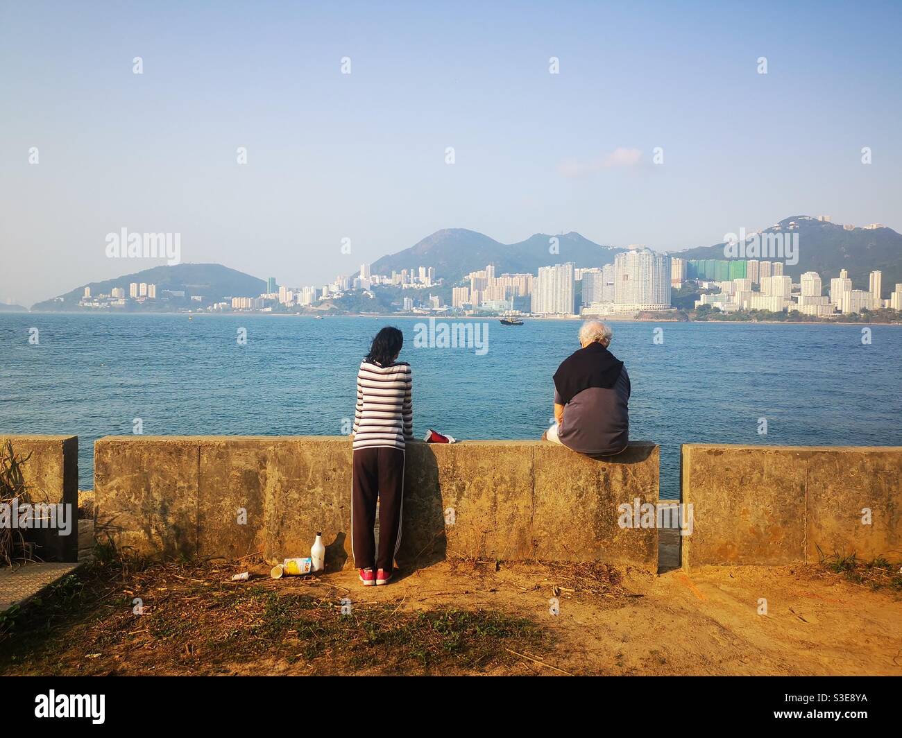 A couple enjoying the view of Hong kong island from Lamma island. - Smartphone Captured Stock Image