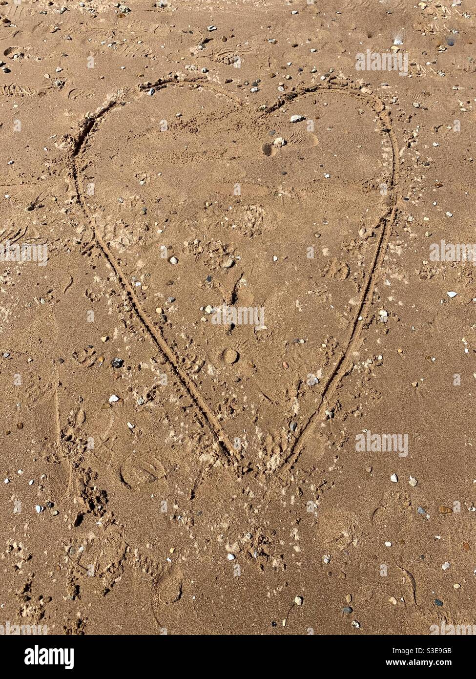 Huge heart sketched into the sandy beach. - Smartphone Captured Stock Image