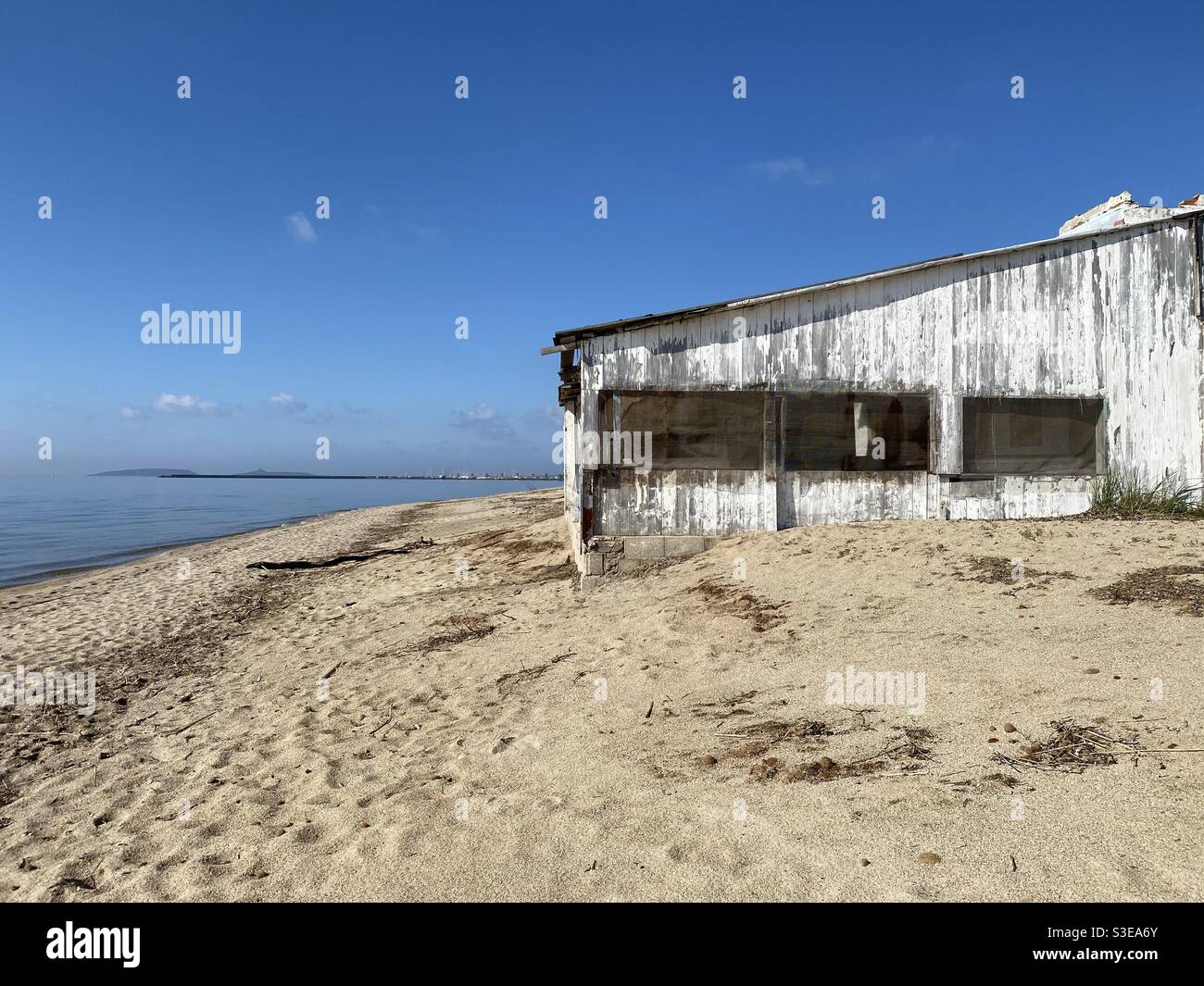 A dismissed beach restaurant made of wood and washed out by saltiness, bad weather and the passing of time. Stock Photo