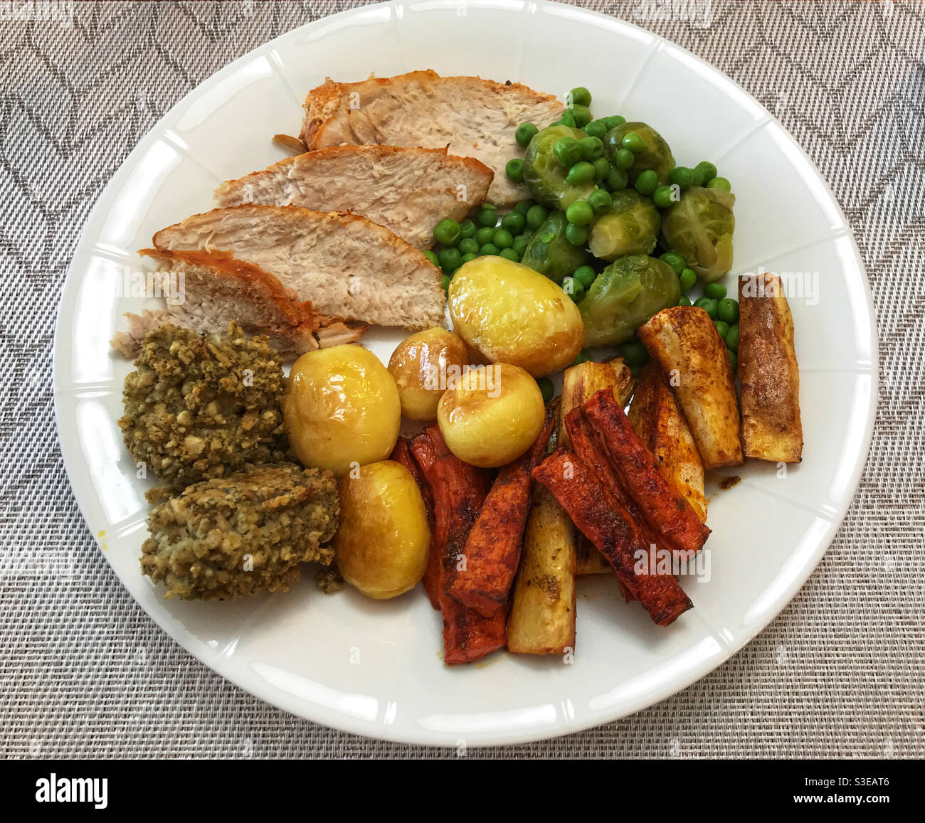 Roast turkey dinner with stuffing, potatoes, parsnips, carrots, sprouts and peas. Stock Photo