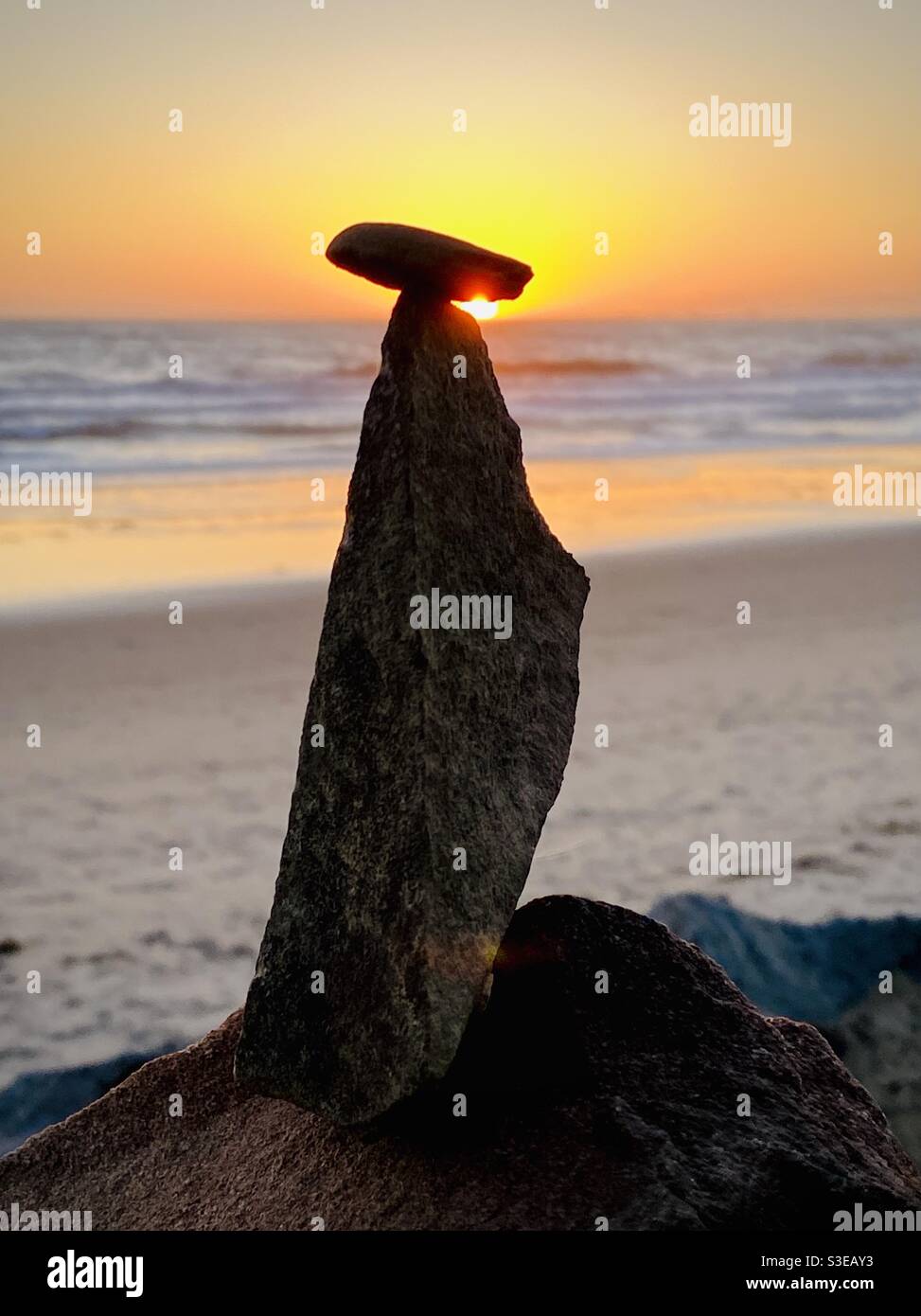 A rock balancing on a rock. Stock Photo