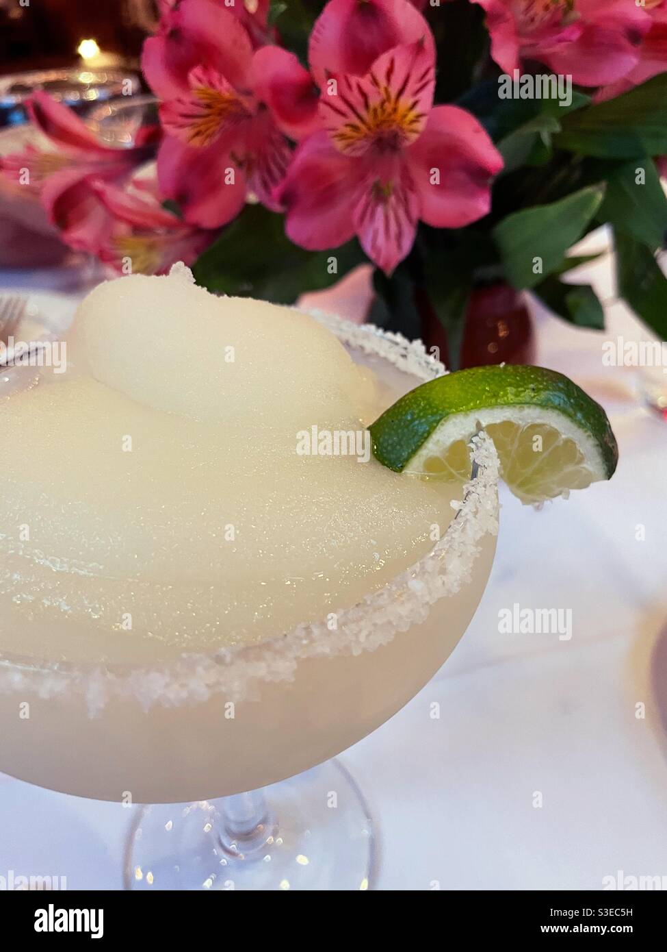 Close up of a frozen margarita with salted rim and lime slice at an
