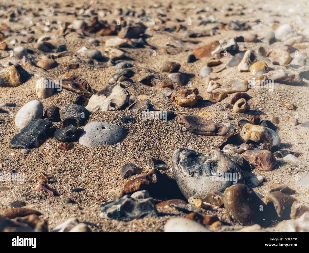 Pebble stones on a sand beach - Smartphone Captured Stock Image