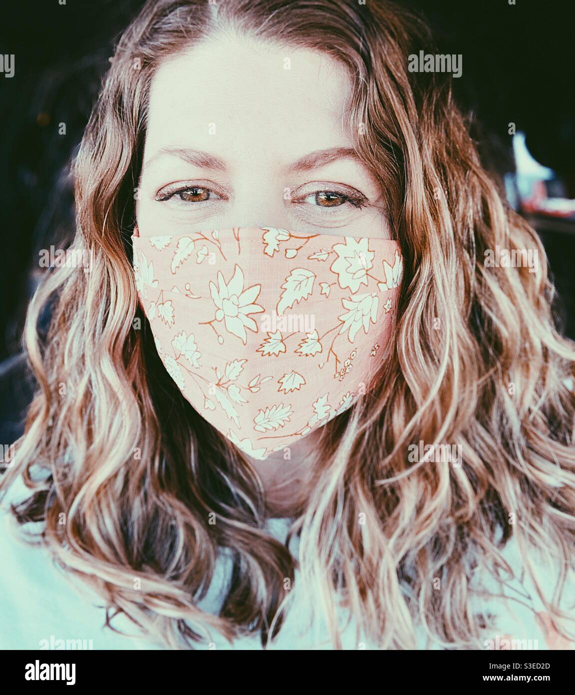 Woman wearing a mask and smiling. - Smartphone Captured Stock Image