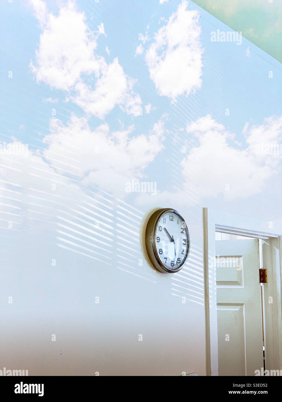 The reflection of the blue sky with the white clouds on the wall & the ...
