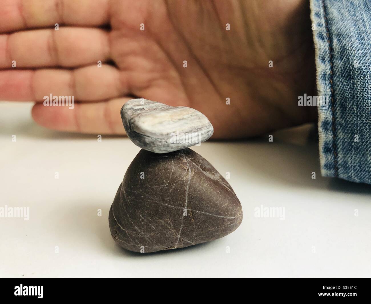 Keeping balance , balancing rocks and hand of a person - Smartphone Captured Stock Image