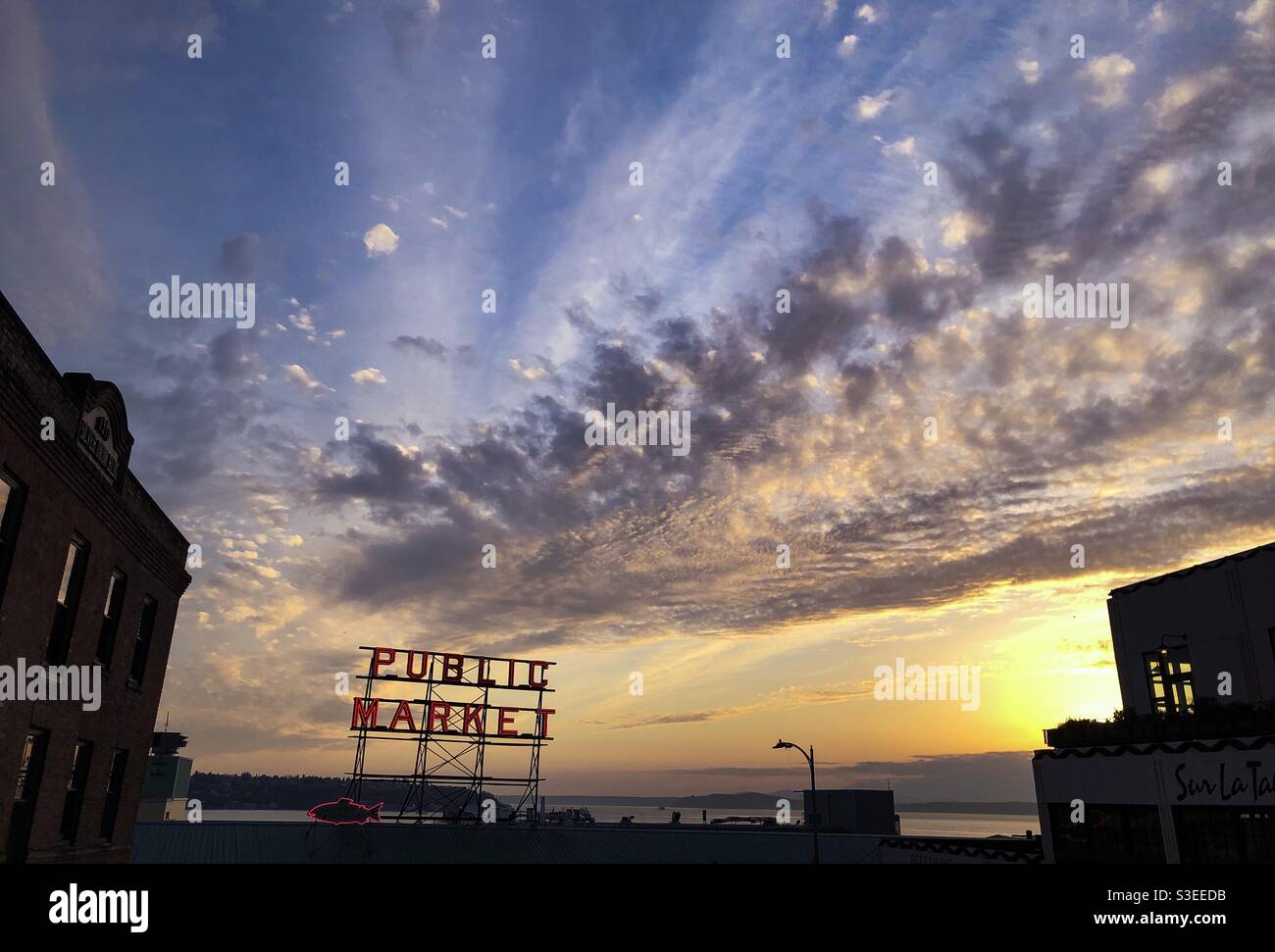 Seattle, USA 1st Apr, 2021. Sunset over the famous neon Pike Place Market with a dramatic sky. - Smartphone Captured Stock Image