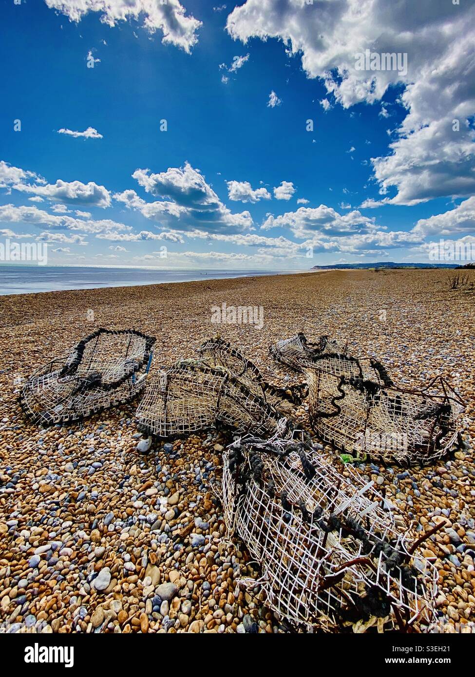 Lobster pots washed-up on Winchelsea beach near Pett Level, Kent, England. Stock Photo