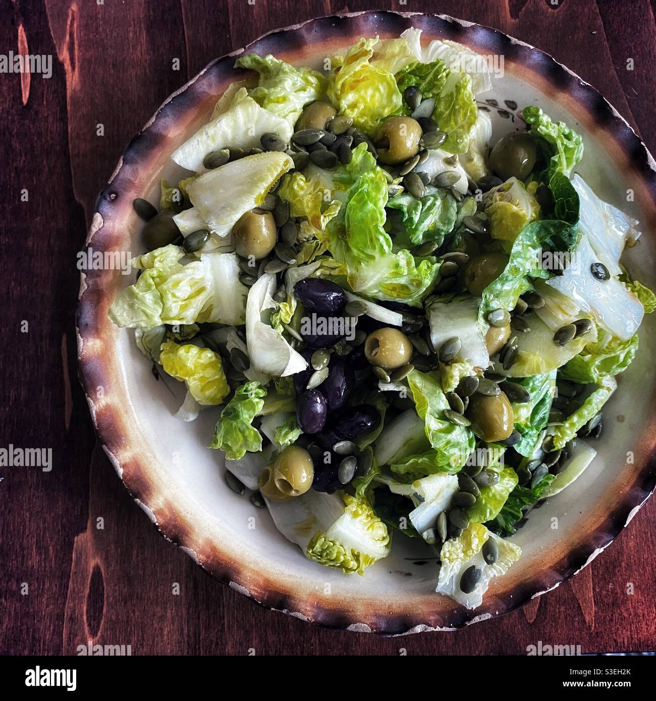 Green salad with olives on a vintage bowl Stock Photo