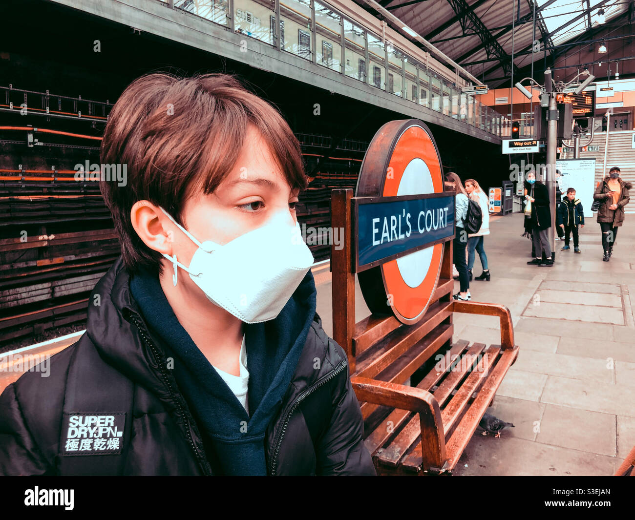 A boy wears a face mask as a precaution due to coronavirus at Earl’s Court London Underground Station. - Smartphone Captured Stock Image