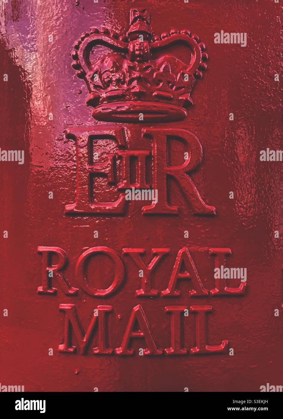 The embossed metal sign on a red British Royal Mail post box celebrating the reign of ER11 or Queen Elizabeth ll - Smartphone Captured Stock Image