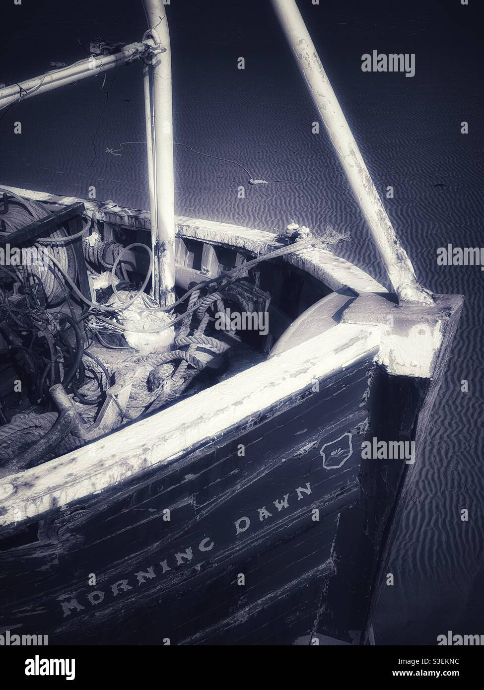 Old fishing trawler grounded in a harbour. - Smartphone Captured Stock Image