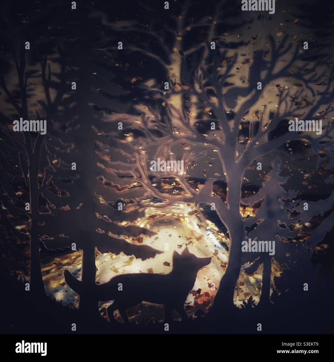 A close up photograph of the outside decoration of a bottle of gin. Woodland creatures and trees cut out detail - Smartphone Captured Stock Image