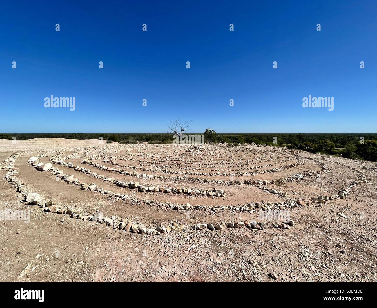 Scenic view of a hand laid stone labyrinth against clear blue sky at the First Shaft Lookout in Lightning Ridge, New South Wales, Australia Stock Photo