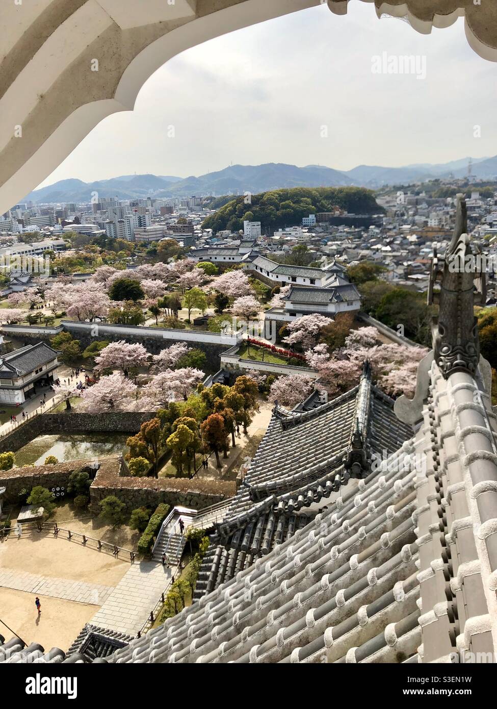 View from Himeji Castle at Himeji town and gardens with mountains in the background, Japan. - Smartphone Captured Stock Image