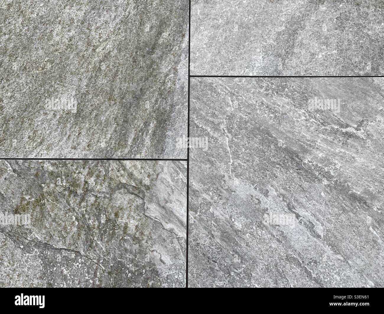 Contrast between clean and dirty parts of a garden patio after cleaning with a pressure washer - Smartphone Captured Stock Image